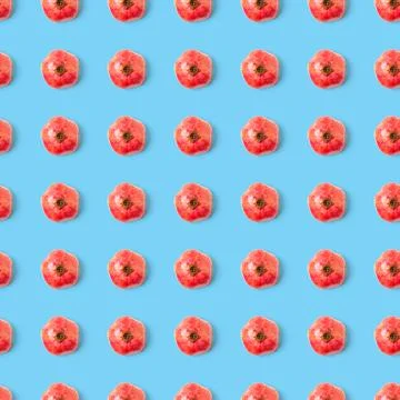 Seamless pattern with red pomegranate fruit on blue background. Minimal flat lay Stock Photos