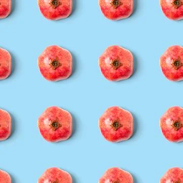 Seamless pattern with red pomegranate fruit on blue background. Minimal flat lay Foto stock