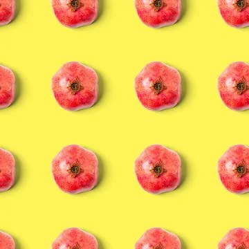 Seamless pattern with red pomegranate fruit on yellow background. Minimal flat Stock Photos