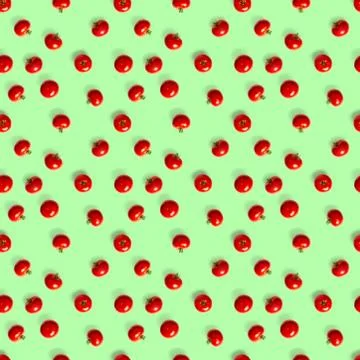 Seamless pattern with red ripe tomatoes. Tomato isolated on green background. Stock Photos