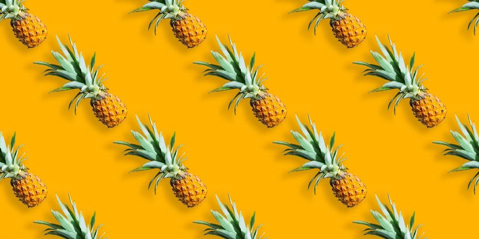 Seamless pattern of ripe pineapples isolated on orange background. Exotic fruit Stock Photos