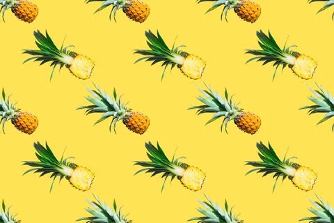 Seamless pattern of ripe pineapples isolated on yellow background. Top view Stock Photos
