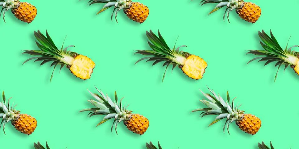 Seamless pattern of ripe pineapples isolated on green background. Top view Stock Photos