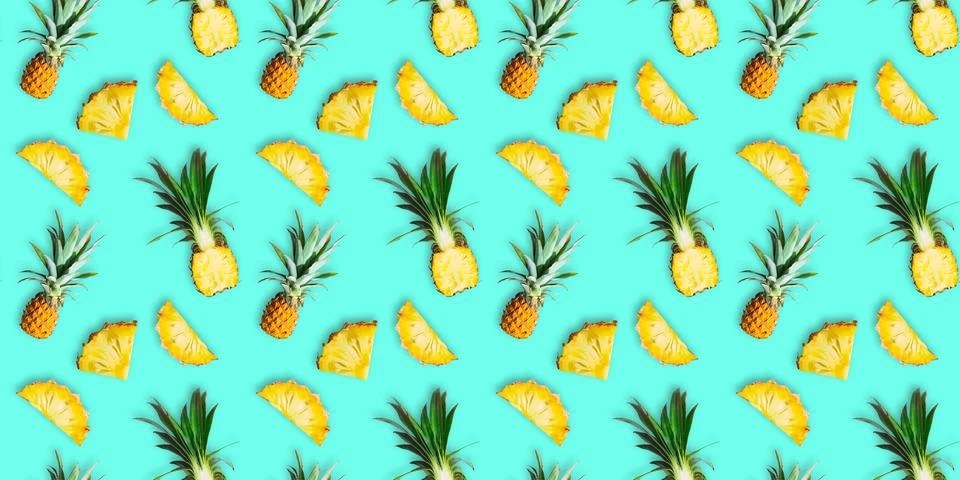 Seamless pattern of ripe pineapples isolated on green background. Top view Stock Photos