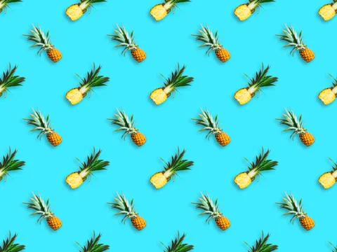 Seamless pattern of ripe pineapples isolated on blue background. Top view Stock Photos
