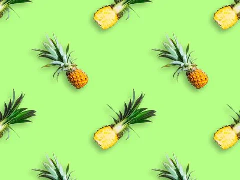 Seamless pattern of ripe pineapples isolated on green background. Top view Stock Photos