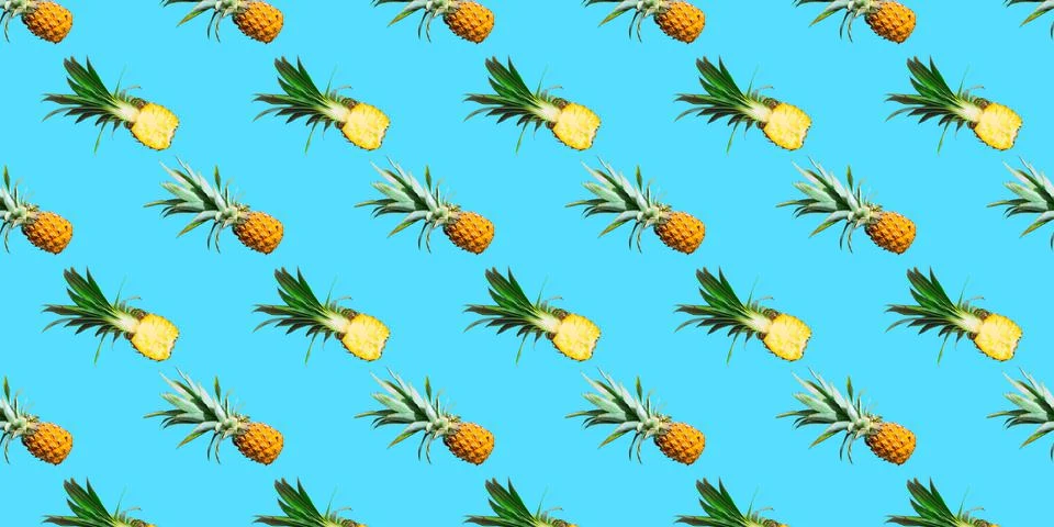Seamless pattern of ripe pineapples isolated on cyan background. Top view Stock Photos