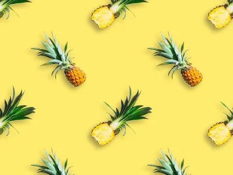 Seamless pattern of ripe pineapples isolated on yellow background. Top view Stock Photos