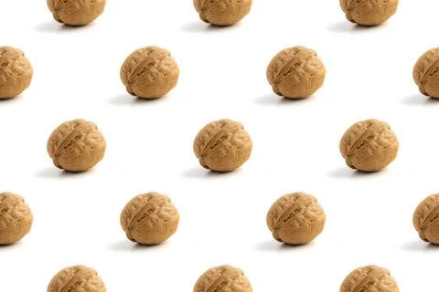 Seamless pattern with ripe whole walnuts on a white background with hard light Stock Photos