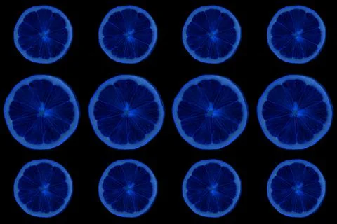 Seamless pattern of round blue slices of ripe lemon on a black background. Flat Foto stock