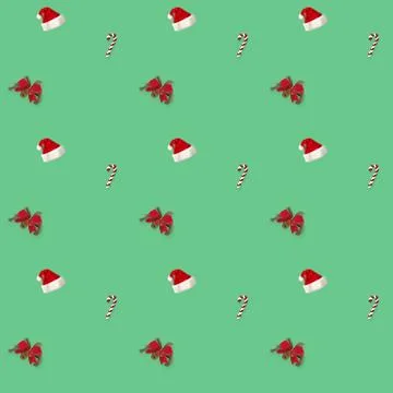 Seamless pattern Santa hat, bow and candy cane candy cane on green background Stock Photos