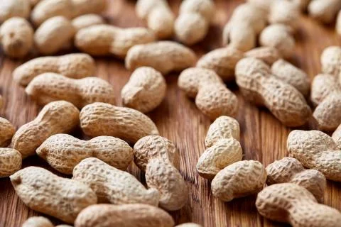 Seamless pattern shelled peanuts isolated on wooden background, top view, close Foto stock