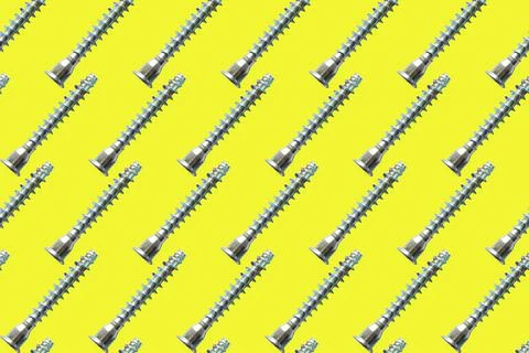 Seamless pattern of silver screws on yellow background Stock Photos