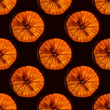 Seamless pattern of slice orange fruit with backlight isolated on black backg Stock Photos