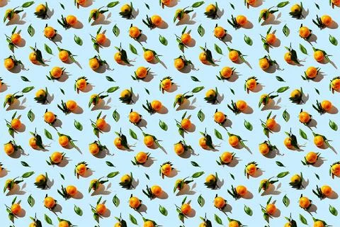 Seamless pattern of tangerines with leaves on blue background. Stock Photos