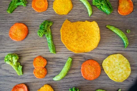 Seamless pattern of vegetable chips with broccoli carrot peas and sweet potato Stock Photos