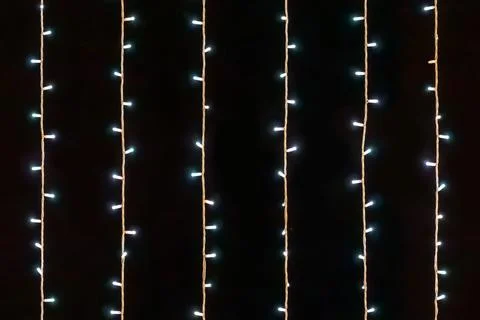 Seamless pattern of vertical glowing blue fairy lights on a black background Fotos de archivo