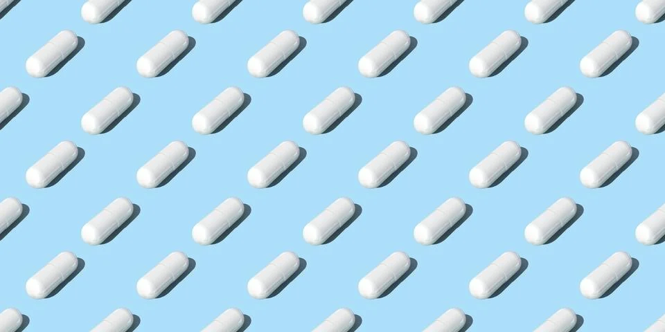 Seamless pattern. White capsule pills on blue background , Medicine concept. Stock Photos