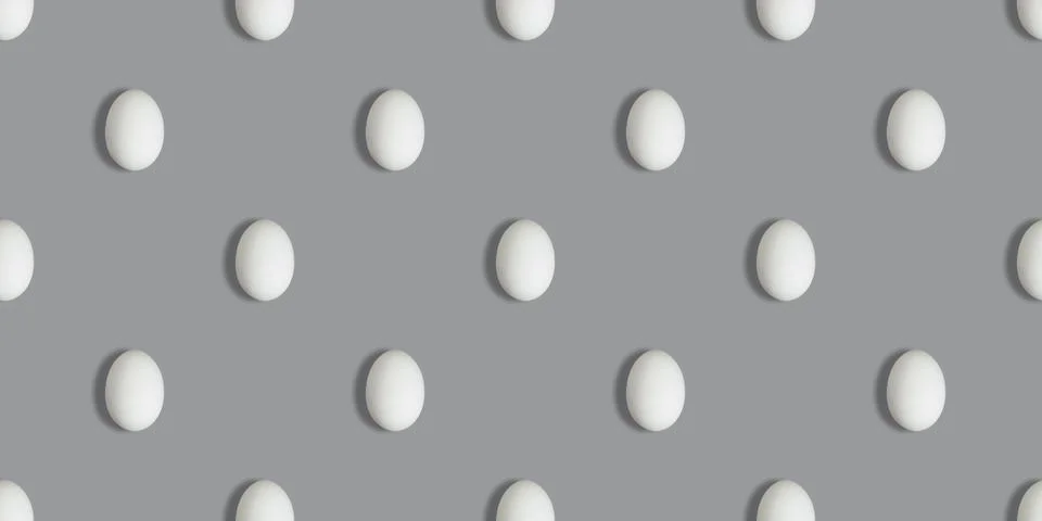 Seamless pattern with white chicken eggs on a gray background. Stock Photos