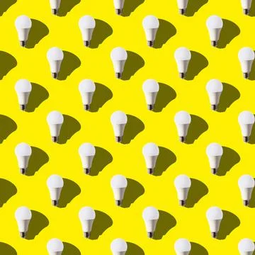 Seamless pattern white light bulb on yellow background shadow on the right. g Stock Photos