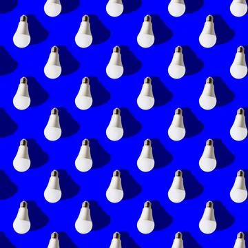 Seamless pattern. white lightbulbs is down on dark blue background. geometric Stock Photos
