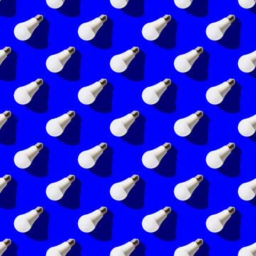 Seamless pattern. white lightbulbs is left down on dark blue background. geom Stock Photos