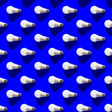 Seamless pattern. white lightbulbs is left on dark blue background. geometric Stock Photos