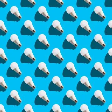Seamless pattern. white lightbulbs is left up on light blue background. geome Stock Photos