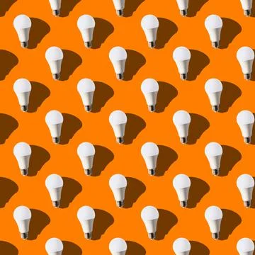 Seamless pattern. white lightbulbs is up on orange background. geometric arra Stock Photos