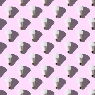 Seamless pattern. white lightbulbs is up on pink background. geometric arrang Stock Photos