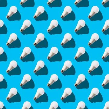 Seamless pattern. white lightbulbs is right up on light blue background. geom Stock Photos