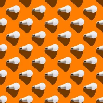 Seamless pattern. white lightbulbs is right on orange background. geometric a Stock Photos