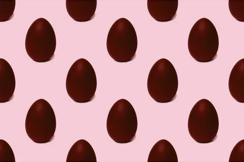 Seamless pattern of whole chocolate Easter eggs on a pink background, tinted. 스톡 사진