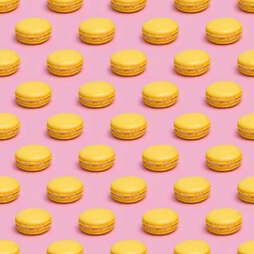 Seamless pattern with yellow macaron cookies on a pink background Stock Photos