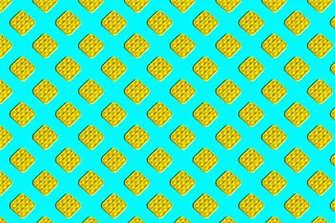 Seamless pattern of yellow trendy popit toys on a turquoise background. Stock Photos