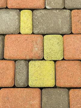 Seamless texture of street tiles. Pattern of gray yellow and pink paving slab Stock Photos