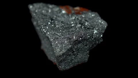 Seamlessly rotating a gray mineral (Hematite) in front of black background Stock Footage 104593641