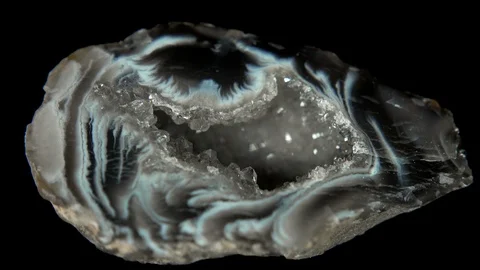 Seamlessly rotating a mineral (Oco Agate Geode) in front of black background Stock Footage 104594021