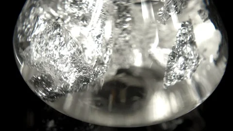 Seamlessly rotating silver in water in front of black background Stock Footage 104329774