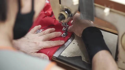 Seamstrees working on a vintage sewing machine and clothes. Stock Footage 137679798