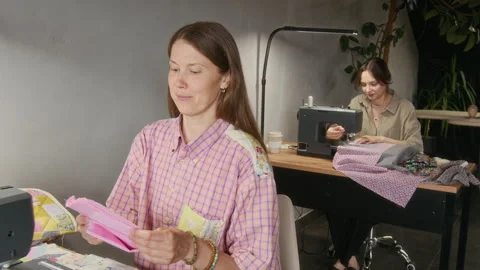 Seamstress Asking Apprentice to Pass Piece for Fabric for Sewing on Machine Video stock 315762800