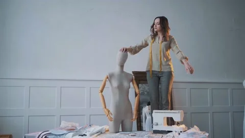 Seamstress chooses correct position of the head of mannequin in sewing workshop Stock Footage 130330823