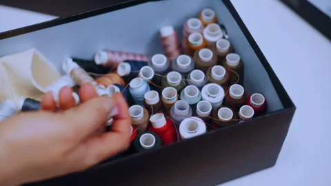Seamstress choosing colored thread for sewing Vidéo 335931140