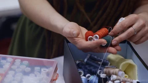Seamstress choosing colored thread for sewing Видео 336247609