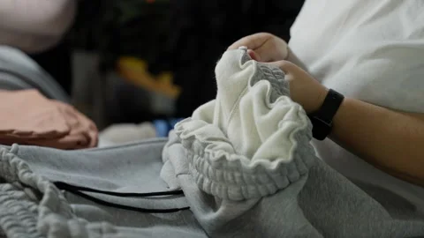 A seamstress cuts threads from ready-made clothes in a sewing factory Stock Footage 262275476