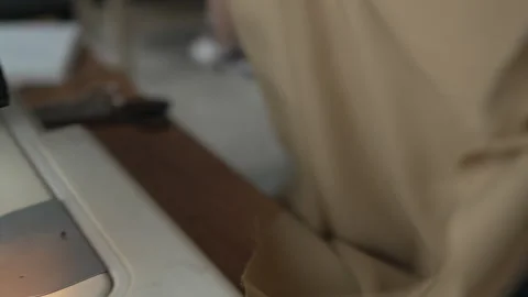 Seamstress cutting thread and sewing fabric on a machine Stock Footage 326005884