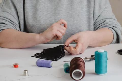 Seamstress does running stitch a pattern pieces of clothing Stock Photos