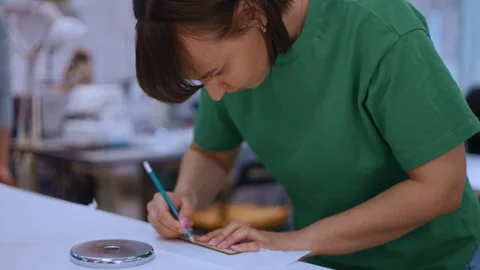 Seamstress drawing a sewing pattern on fabric Vídeos de archivo 335930790
