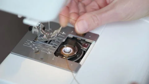 Seamstress hands inserting bobbin into sewing machine Stock Footage 344283082