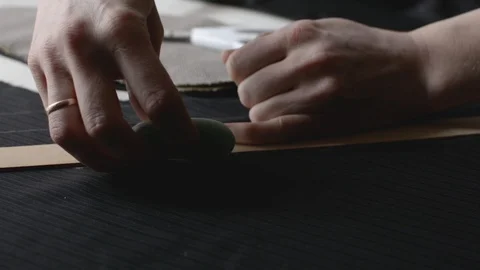 Seamstress hands making marks on the dark textile using the soap, close view Stock Footage 129323582